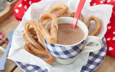 Churros à la cannelle et au sucre en poudre, accompagnés d’un chocolat chaud